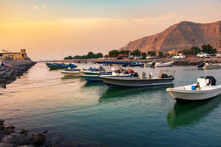 Khasab, Oman - October 5, 2018: Khasab city creek and desert rock scenery with characteristic Arabian houses at sunsetのeditorial素材
