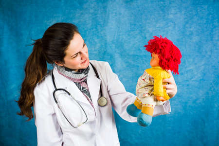 Female doctor holding a cheerful baby doll