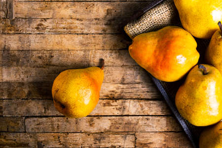 Organic pears on rustic wooden background top viewの写真素材