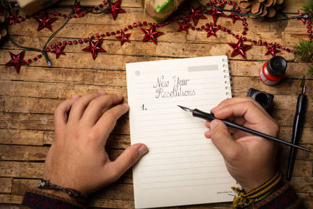 Young man's hands making a list of New Year resolutionsの写真素材