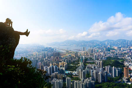 Man taking photo of a Hong Kong cityscape view from the Lion rockの写真素材