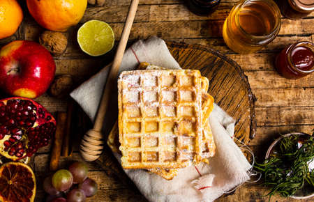 Homemade waffles served with fruits and honey top view
