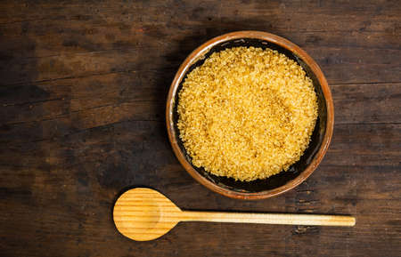 Brown sugar in a bowl on a wooden table top view