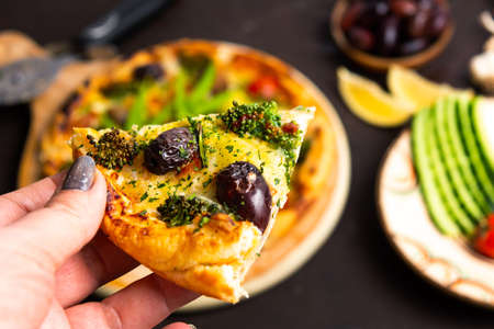 Woman holding pizza slice first person point of viewの写真素材