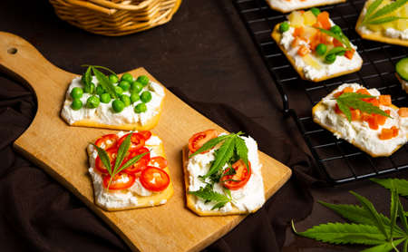 Marijuana sandwiches with vegetables on a cutting board top viewの写真素材