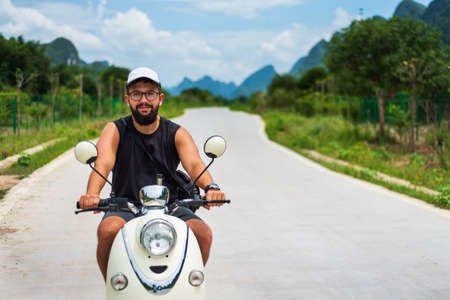 Male traveler riding motorbike on Asian tripの写真素材