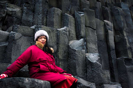 Female traveler on the rocks of Black sand Reynisfjara Beach in Icelandの写真素材