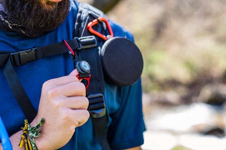 Equipped hiker with speaker, compass and water pipe close upの写真素材