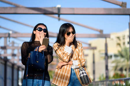 Fashionable girls laughing on the street closeupの写真素材