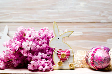 Easter bunny with decorated eggs and fresh hyacinth flowers