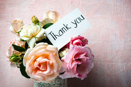 Rose flowers bouquet in a vase with a thank you noteの写真素材