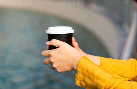 Woman having a cup of coffee outdoors close upの写真素材