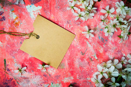 Cherry blossom flowers and an empty card on red backgroundの写真素材