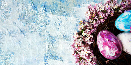 Easter eggs and colorful lilac flowers arrangementの写真素材