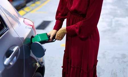 Woman refiling petrol on gas station close up