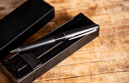 Black pen on a wooden table top viewの写真素材