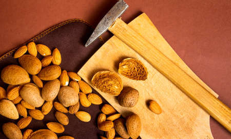 Bunch of almonds and a hammer on a tableの写真素材