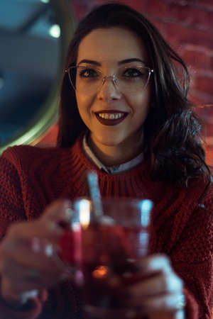 smiling brunette with glasses in a coffee shopの写真素材