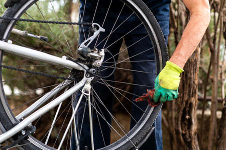 Man cleaning bicycle tire for the new seasonの写真素材