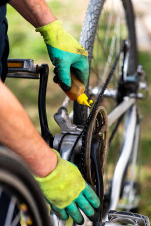 Man lubricating bicycle chain and maintaining for the new seasonの写真素材