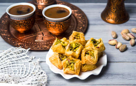 Arabic baklava dessert with coffee in copper cupsの写真素材