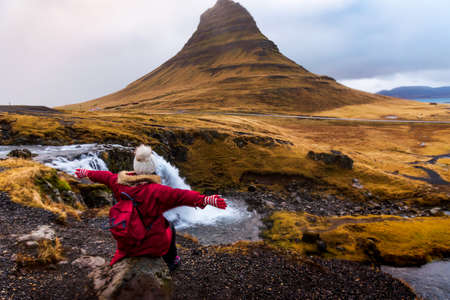 Traveler visiting famous Kirkjufellsfoss waterfall in Icelandの写真素材