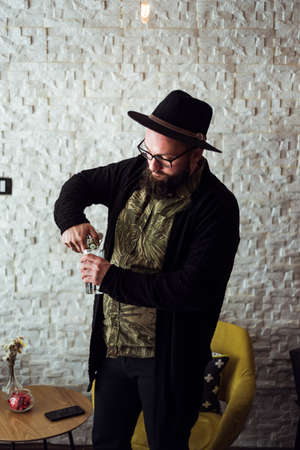 hipster pouring water from a glass bottle
