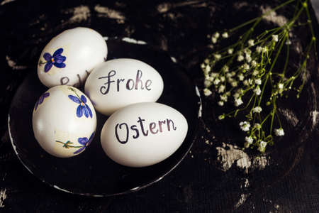 Happy easter written in German on white eggs with flowersの写真素材
