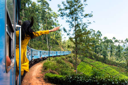 Woman enjoying the train ride through Sri Lanka tea plantations