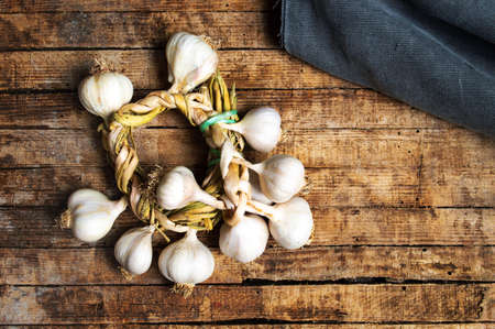 Garlic wreath on a rustic wooden table top viewの写真素材