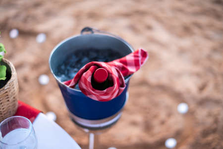 Bottle of wine chilled on a beach for a romantic dinnerの写真素材