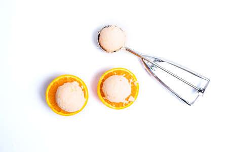 Ice cream scoops on a orange fruit isolated