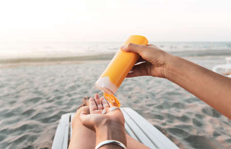 Woman using sun lotion on beach summer vacationの写真素材