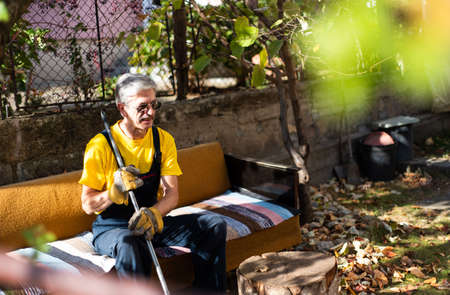 Man sitting on the sofa after cleaning in the backyard