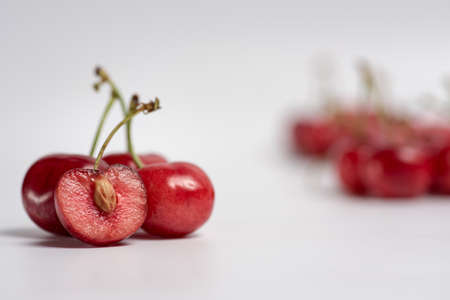 Bunch of fresh cherries and an open cherry with a seedの写真素材