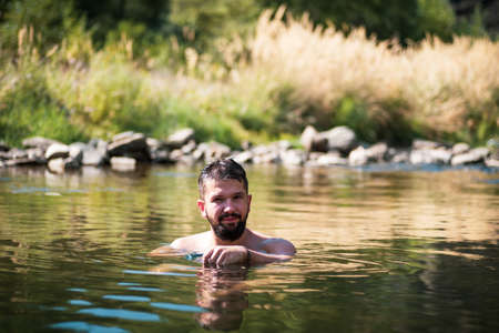 Man cooling down in a river on a hot summer dayの写真素材