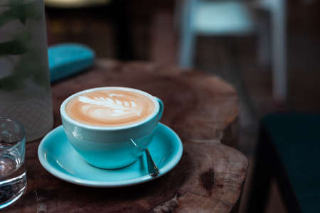 Cup of decorated coffee on a wooden table