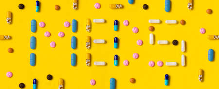 The word Meds written by pills on yellow backgroundの写真素材