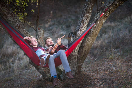 Couple having fun in a hammock on a picnic outdoorsの写真素材