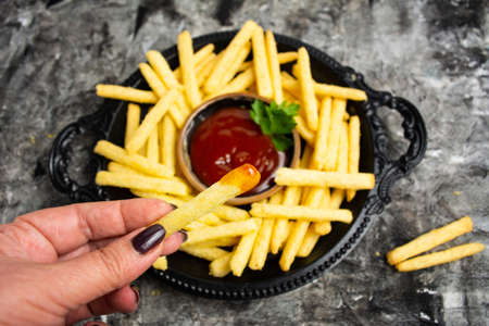Person dipping French fries and tomato sauce first person viewの写真素材