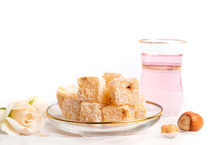 Turkish delight dessert with hazelnuts served with rose teaの写真素材