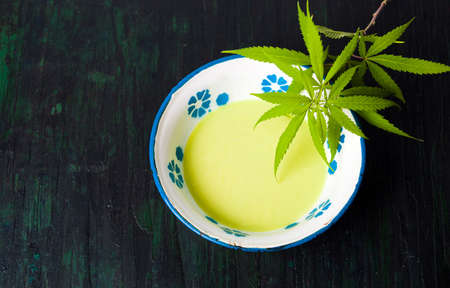 Butter with cannabis plant in a bowl top viewの写真素材