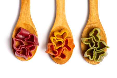 Colorful heart shaped pasta on wooden a spoon isolatedの写真素材