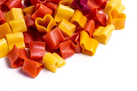 Colorful heart shaped macaroni pasta flat lay isolatedの写真素材
