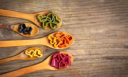 Colorful heart shape macaroni pasta on wooden spoonsの写真素材