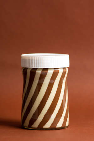 Sweet cream in the jar against brown backgroundの写真素材