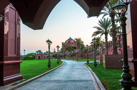 Abu Dhabi, United Arab Emirates - November 1, 2019: Emirates palace in a beautiful yard, one of the most famous landmarks in Abu dhabi at sunsetのeditorial素材