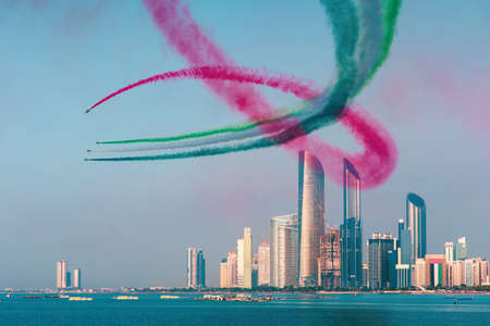 Airplanes flying above Abu Dhabi skyline for the UAE national day celebration air showの写真素材