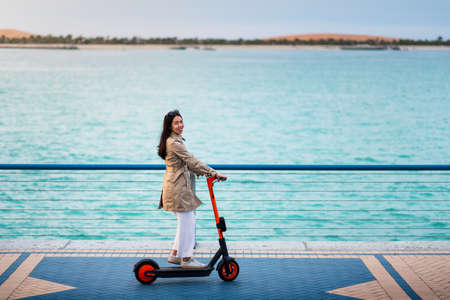 Woman using electric scooter for transportation in a modern city environmentの写真素材