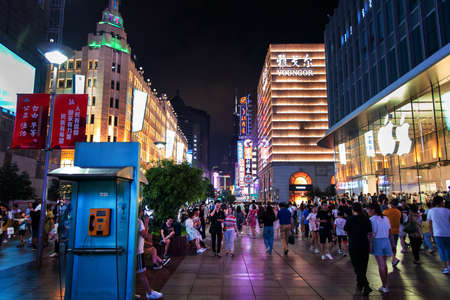 Shanghai, China - August 7, 2019: Nanjing road in downtown Shanghai with neon signs and shops and tourists walking around at nightのeditorial素材